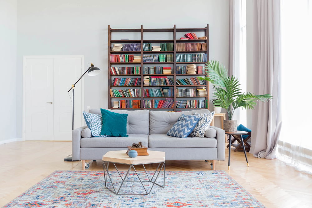 a spacious huge room in light colors. stylish expensive luxury furniture a brilliant bookcase design in the wall.