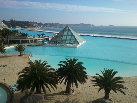View of San Alfonso del Mar, featuring its iconic heated swimming pool, known as “la piscina temperada” or simply “the pyramid,” with the Pacific Ocean in the background.