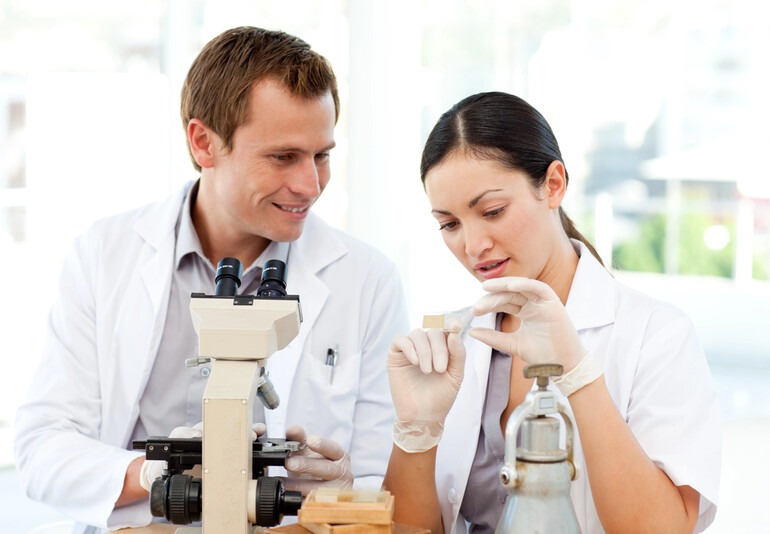 Scientists examining a laboratory sample under a microscope during TB-500 peptide research.