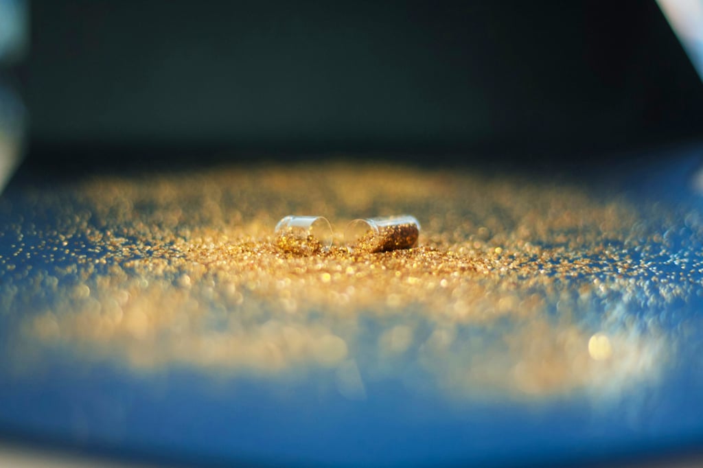 gold glitter pill spilled on a blue surface