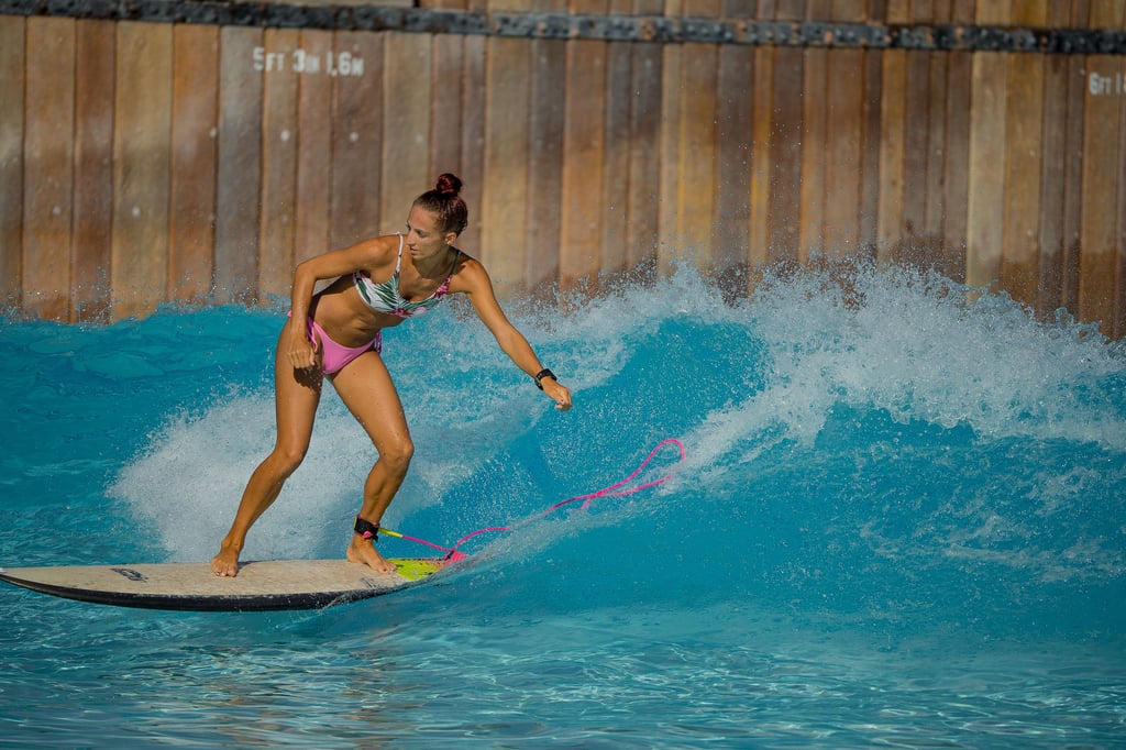 A woman surfing in a wave pool