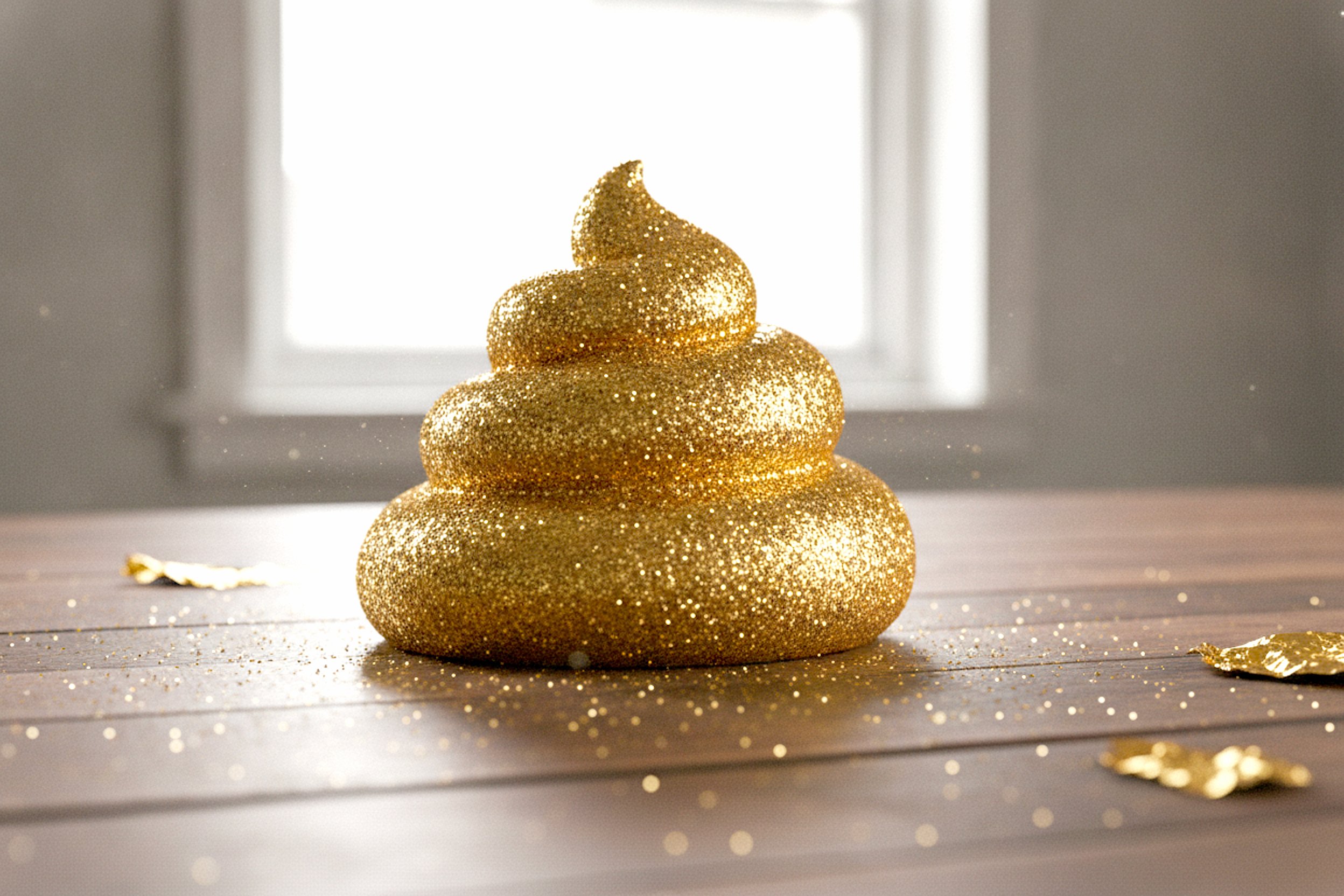 Image of gold glitter poop emoji on a table by a window