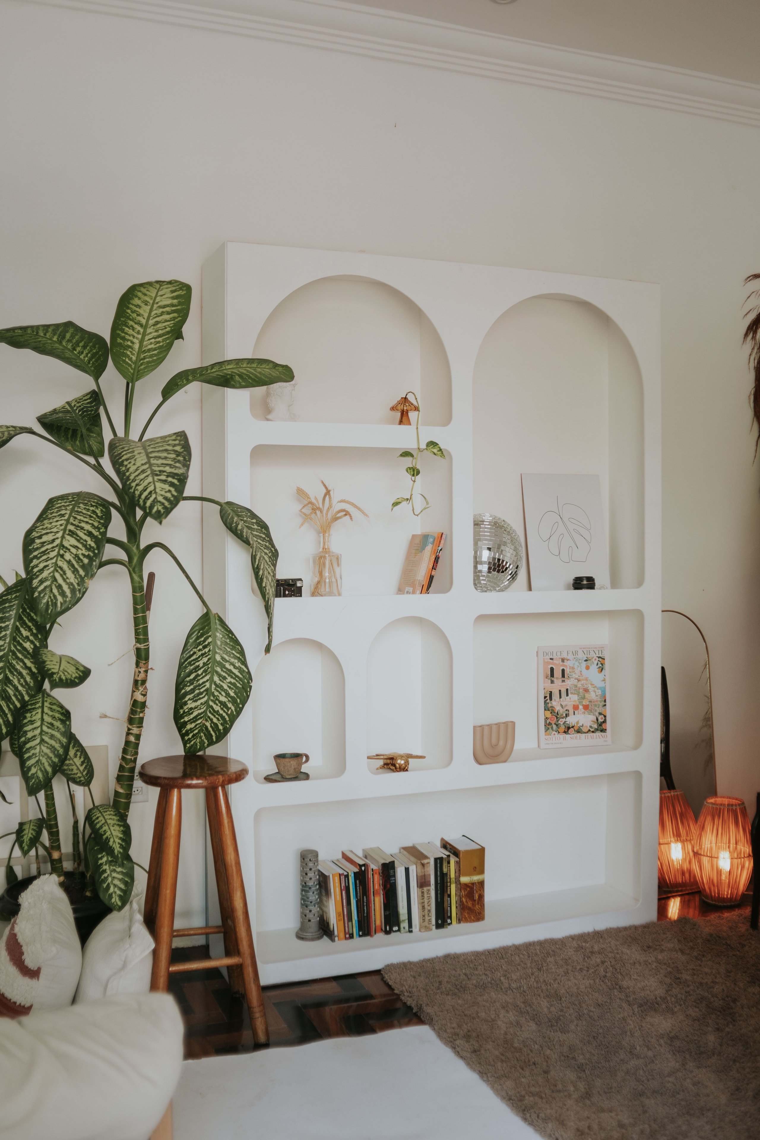 Unique bookcase with asymmetrical shelves and unusual shapes in modern room