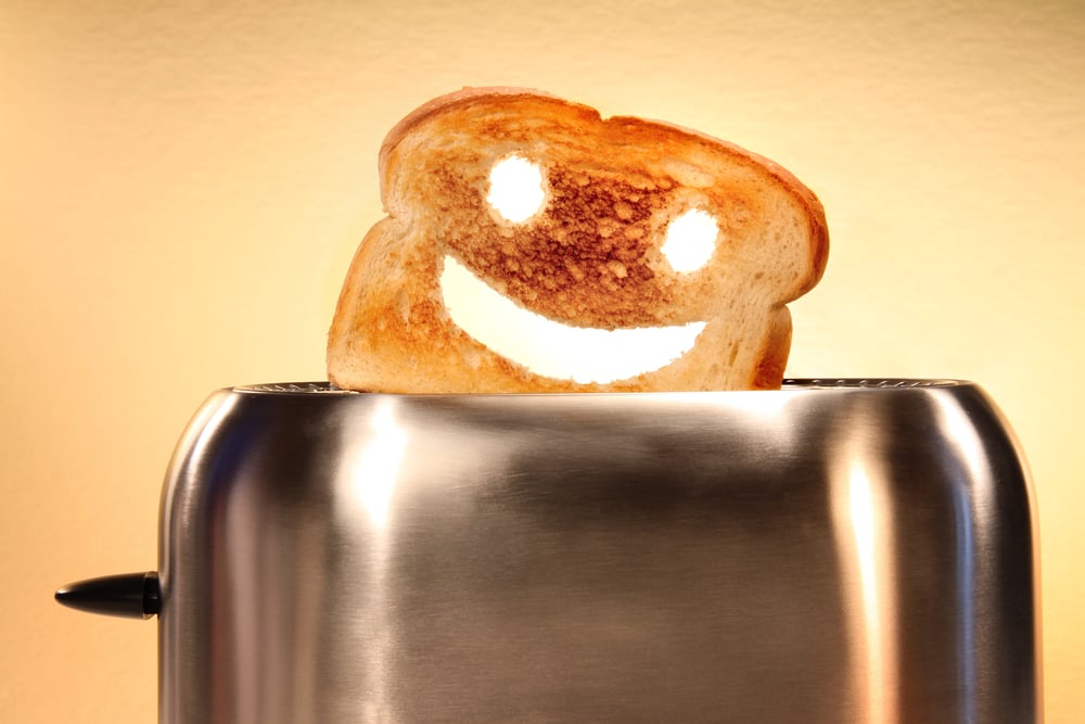 Toast with a smiley face popping out of a toaster