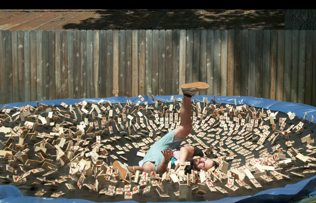 A Guy Leaps Onto A Trampoline Covered With 1000 Mouse Traps