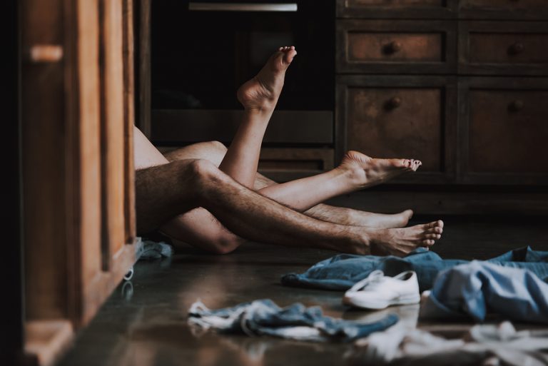 Attractive Passionate Couple Having Sex in Kitchen. Man and Woman Lying on the Floor in the Kitchen at Home and Having Sex. Love Concept. Romantic Date. Relationship. Husband and Wife.