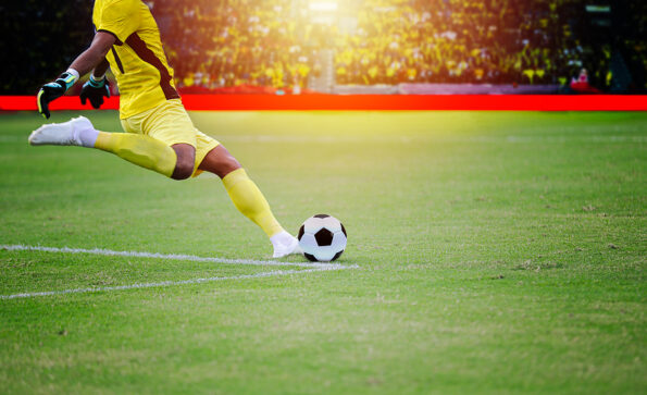 soccer or football player standing with ball on the field for Kick the soccer ball at football stadium