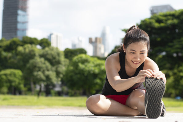 Young Asian woman is excercise warm up in the Park during morning time.