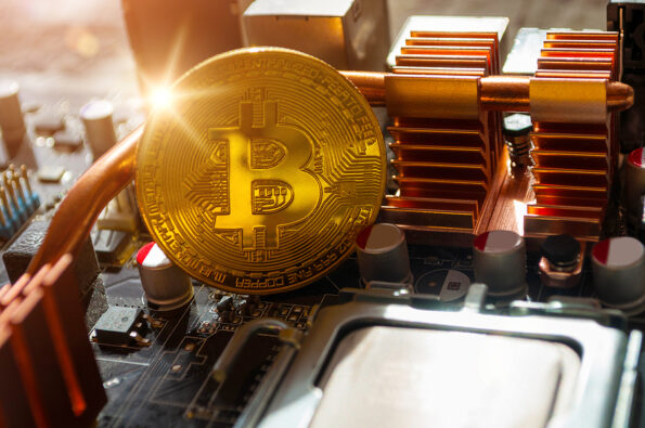 Golden physical bitcoin near the computer components. Business concept of digital cryptocurrency. Blockchain technology and bitcoin mining concept, bitcoin closeup