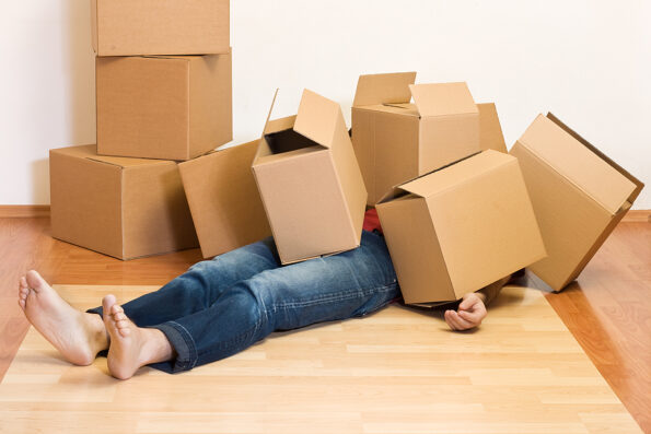 packing unpacking Man covered by lots of cardboard boxes - moving concept