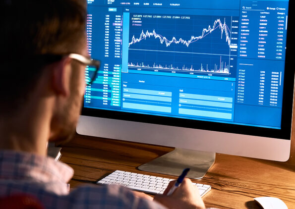 Business man trader broker looking at pc computer screen, investor manager analyzing financial chart, exchange trading online investment data crypto currency stock market graph, over shoulder view.