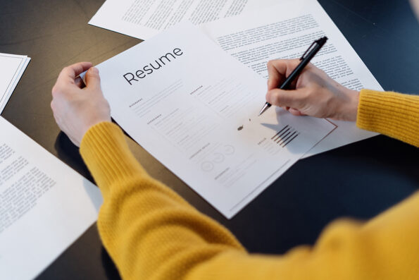 Human resources headhunt and new job employment concept. Cropped view of manager checking cv resume before interview candidature on free vacancy. Woman sitting in office, reading summary information