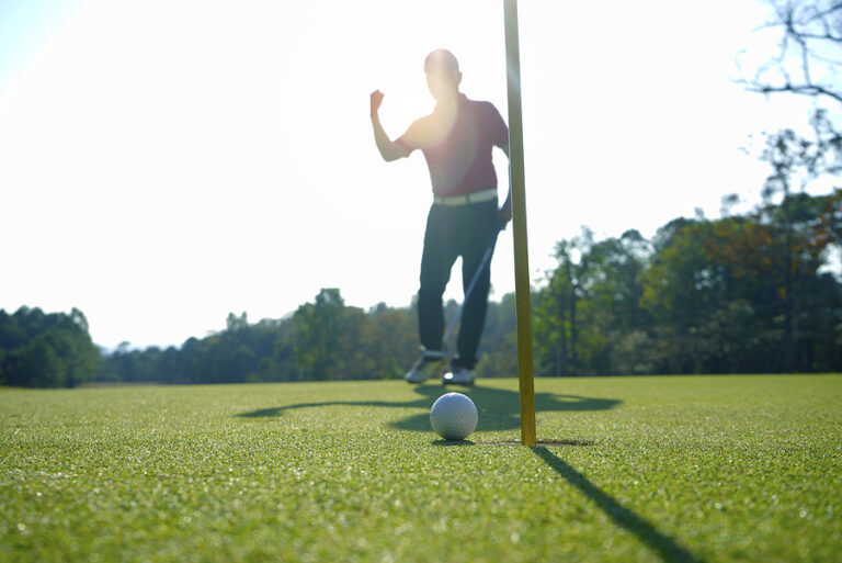 Blurred golfer playing golf in beautiful golf course in the evening golf course with sunshine in thailand.