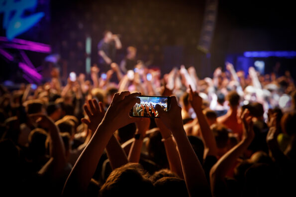 People at a public event. Crowd with raised hands at a concert