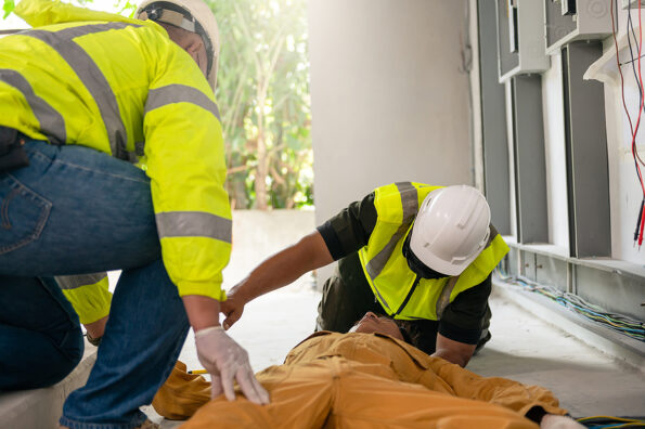 Safety team professional help technician accident electric shock unconscious in site work. Danger workplace.