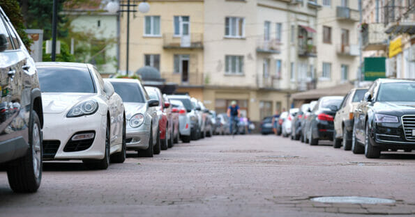Cars parked in line on city street side. Urban traffic concept.