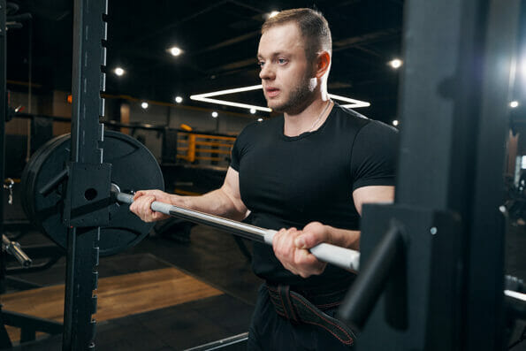 Focused bodybuilder preparing to do weight-lifting exercise