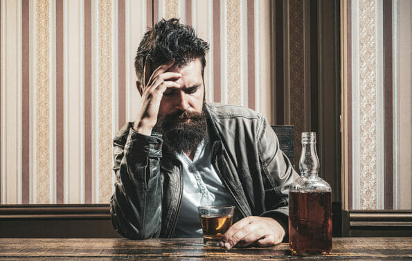 Alcoholism. Addiction crisis. Alcohol addiction and people concept male alcoholic drinking cognac at night. Depressed man in bar with a bottle of alcohol. Stop addiction. Man crisis concept.