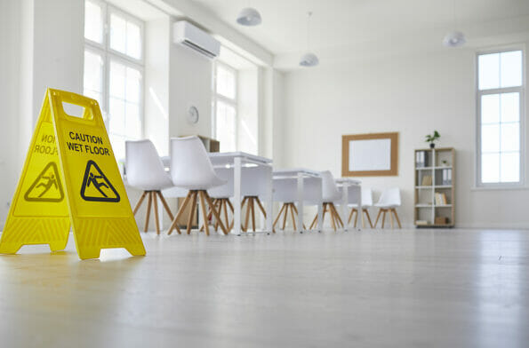 School classroom where cleaning service worker placed sign which reads Caution Wet Floor