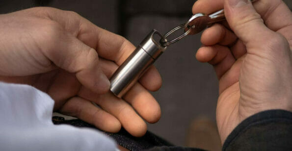 Aerial view of person holding stainless steel capsule attached to their keys
