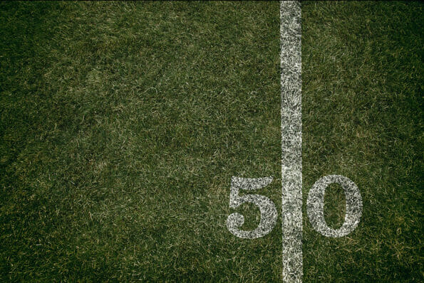 American Football field fifty yard line background image grass and turf inside a stadium