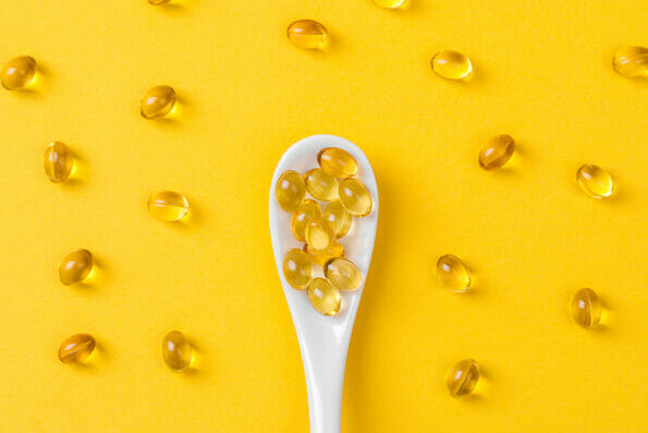 Close up of oil filled capsules on spoon suitable for: fish oil, omega 3, omega 6, omega 9, vitamin A, vitamin D, vitamin D3, vitamin E