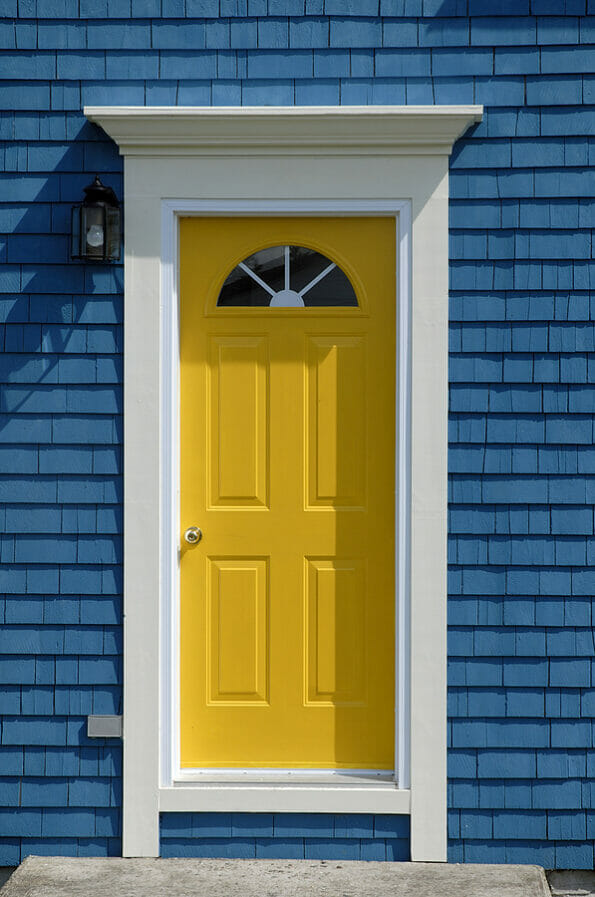 A Bright Yellow Front Door On An Old Traditional Cedar Shake House