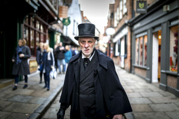 16th February 2018, The Shambles, York. Ghost Tour guide dressed as a menacing Victorian male undertaker in a top hat sneering at the camera in the UK