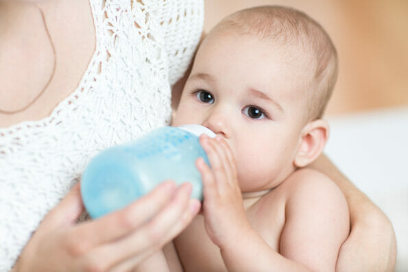 mother feeds baby boy milk from bottle ** Note: Shallow depth of field