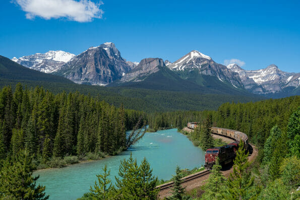 Freight train makes its way through Morants Curve in Banff National Park in the Canadian Rockies on a summer day