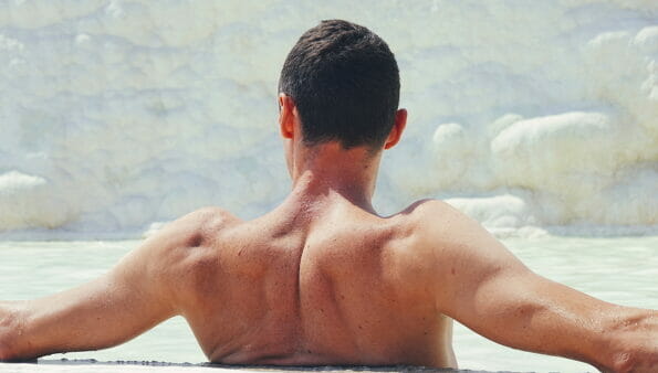 Man Enjoying Water in thermal spring at Pamukkale, Turkey. Back of beautiful man